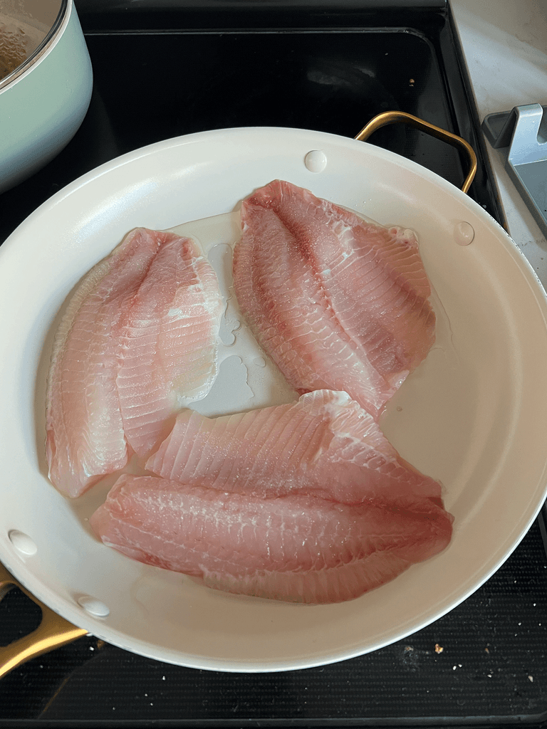 올리브유를 두른 팬에 틸라피아를 굽는 과정